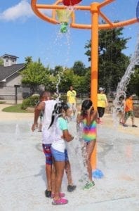 Group of kids getting wet at summer camp water park