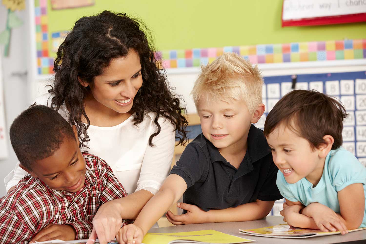 Preschool teacher with three kids working on day care activity