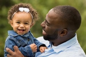 Dad holding smiling baby