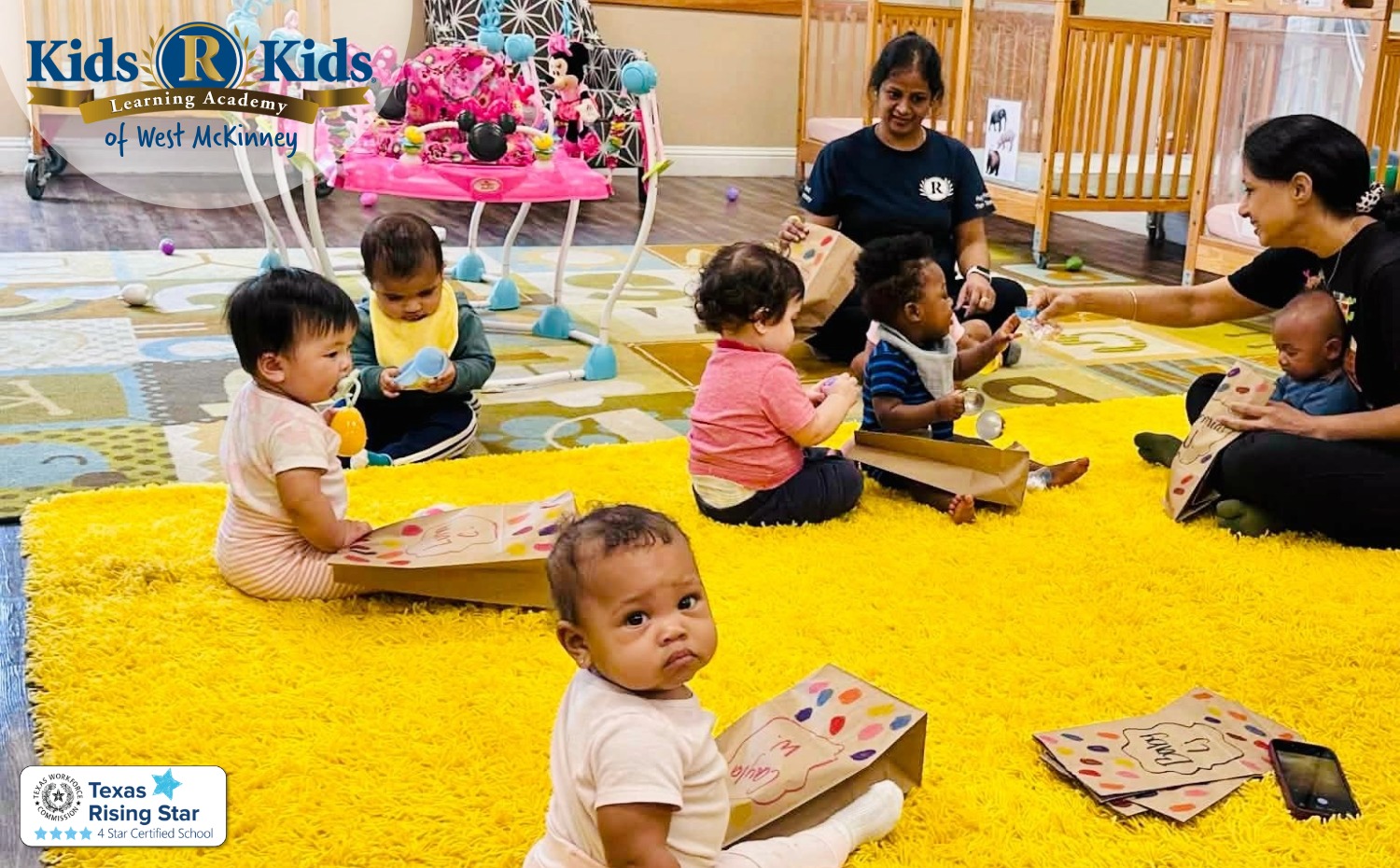 Infant teacher reading with babies at Kids R Kids West McKinney