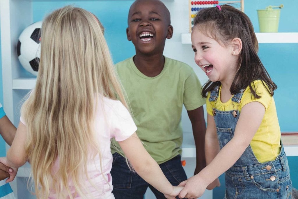 Pre-K group holding hands and smiling