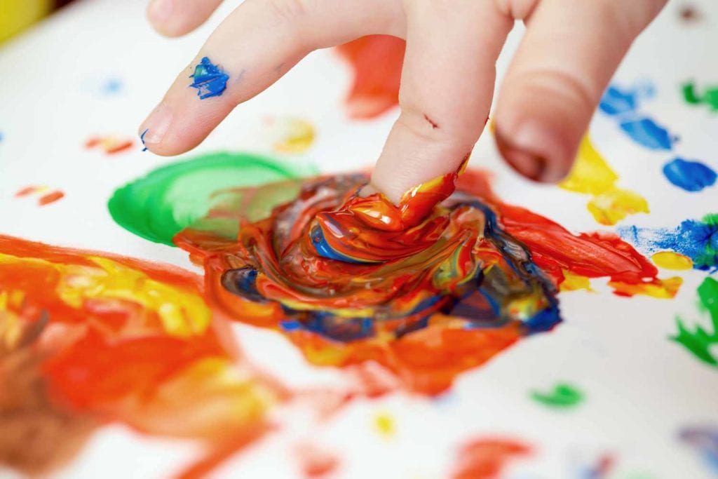 child finger painting at child care center